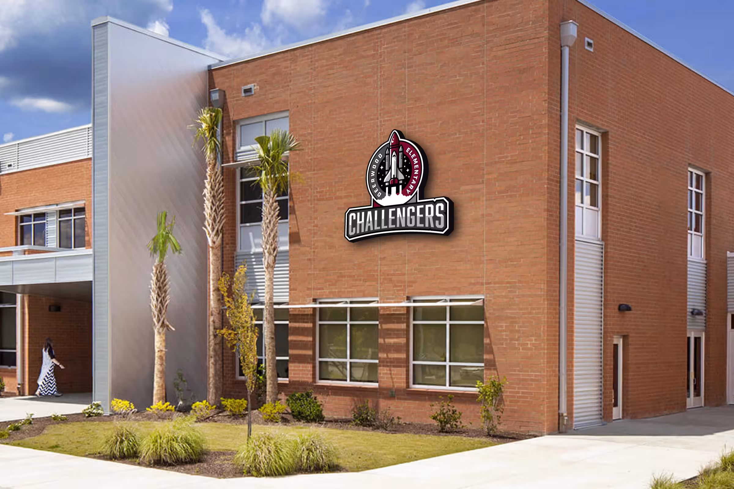 Exterior brick facade with mounted Challengers crest—high‑visibility campus identification at main entry