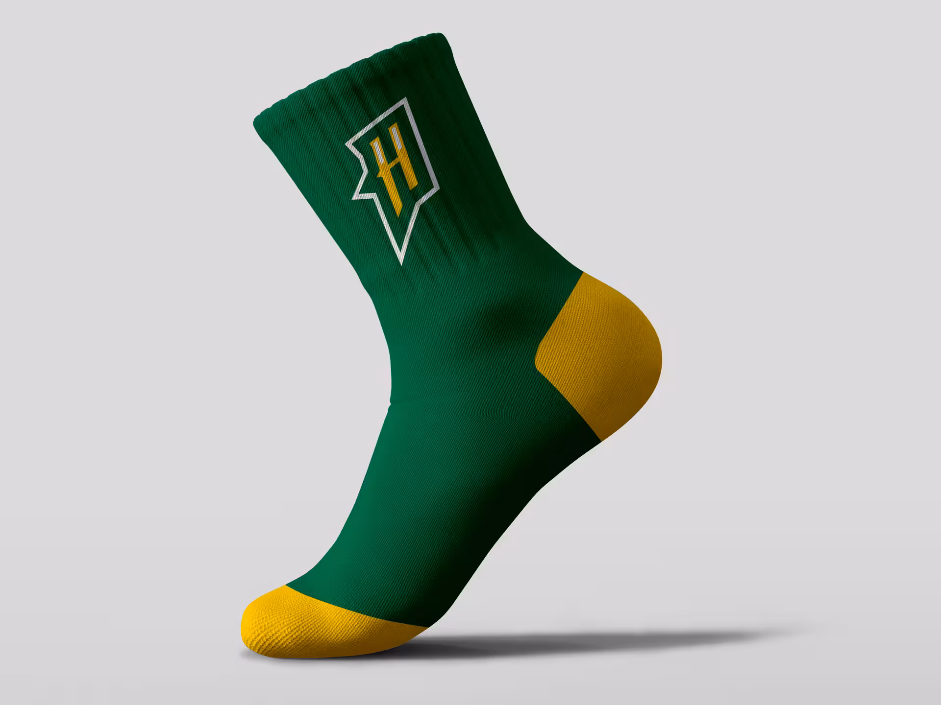 Athletic crew sock design with the 'H' monogram diamond emblem on forest green fabric with contrasting gold heel and toe—an example of how the Hornets brand extends to complete uniform systems and team merchandise
