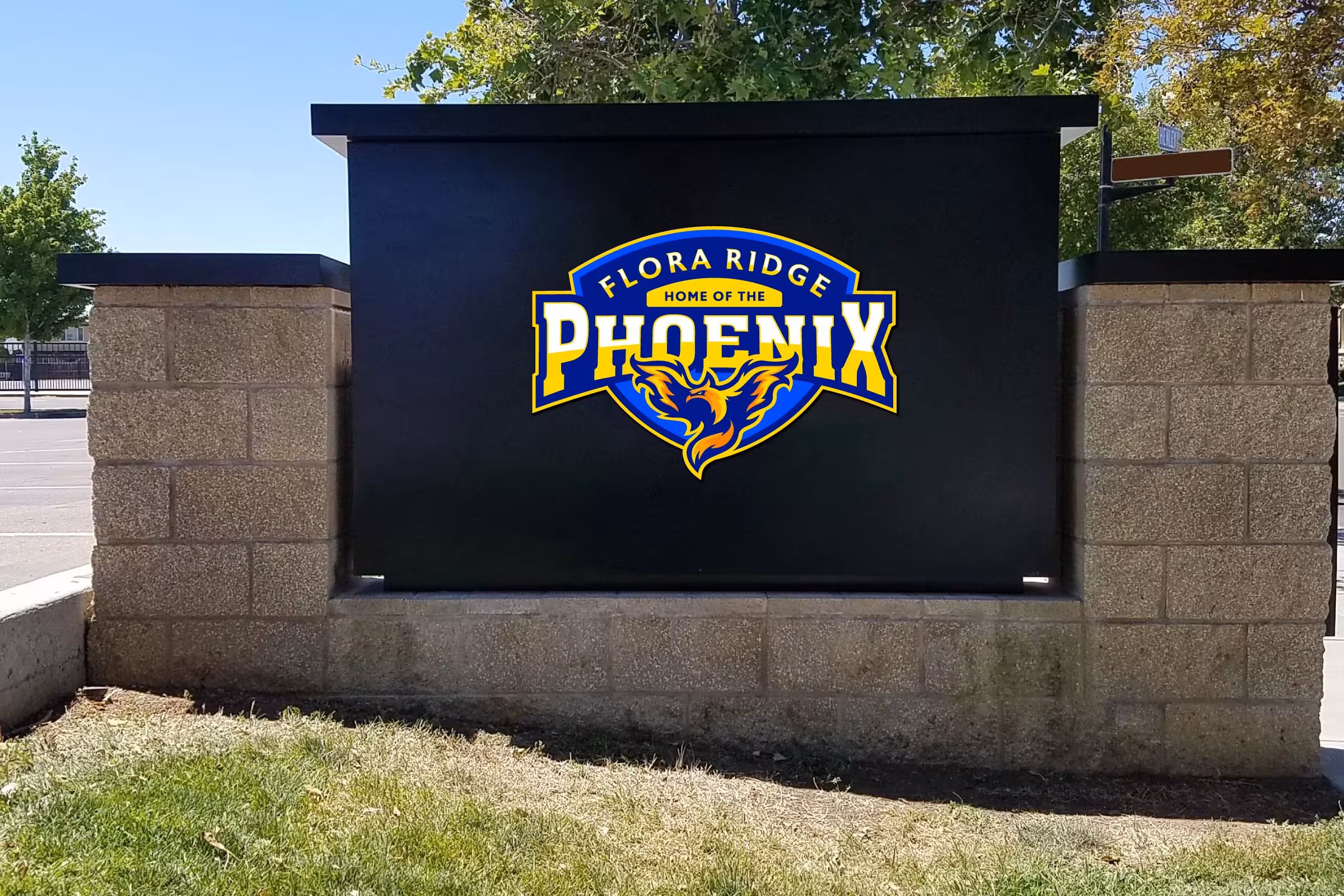 Campus monument sign—primary Phoenix crest applied to matte black entry marker for high‑visibility school identification