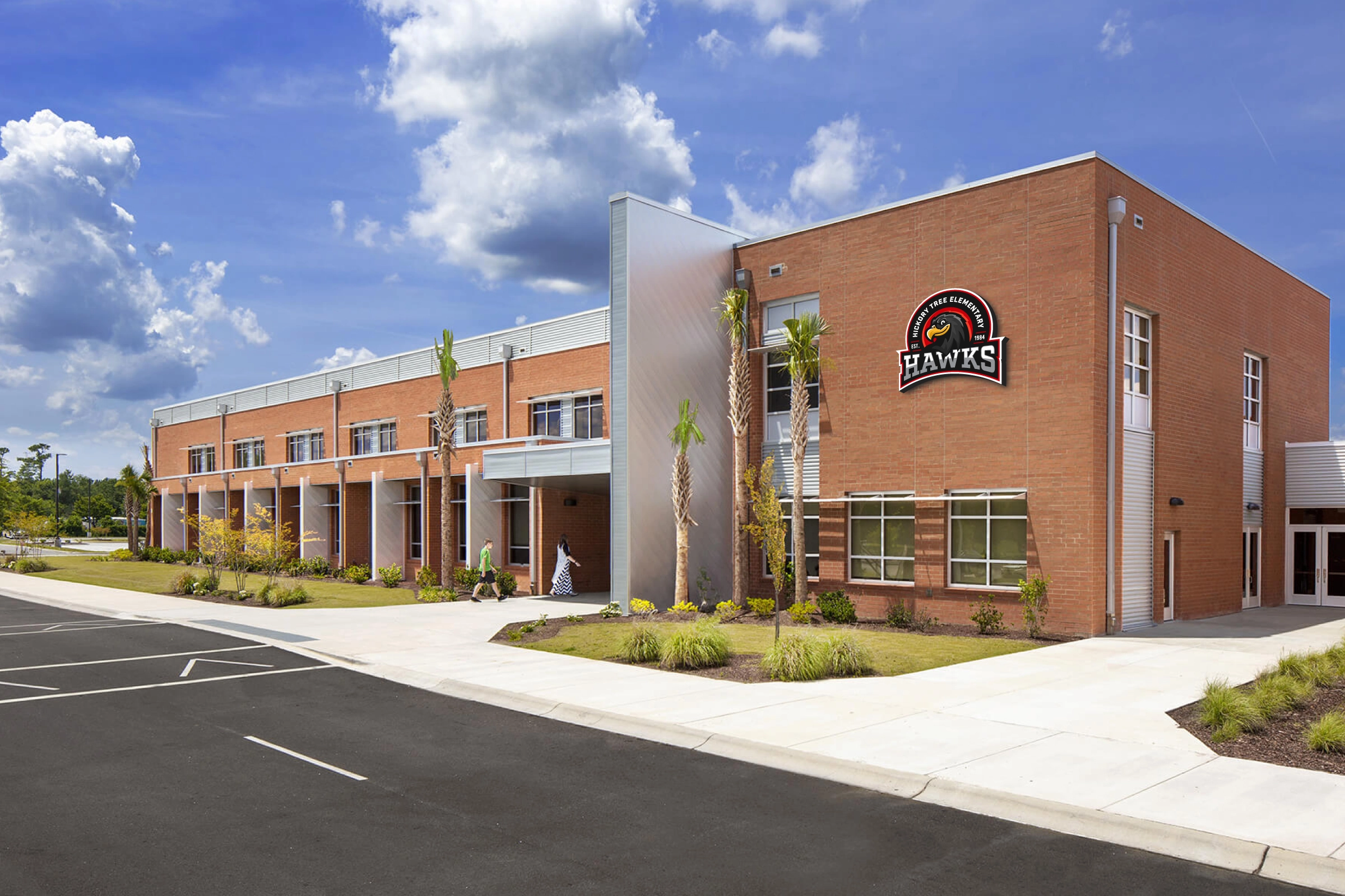 Campus facade with mounted Hawks crest—architectural identification on brick elevation